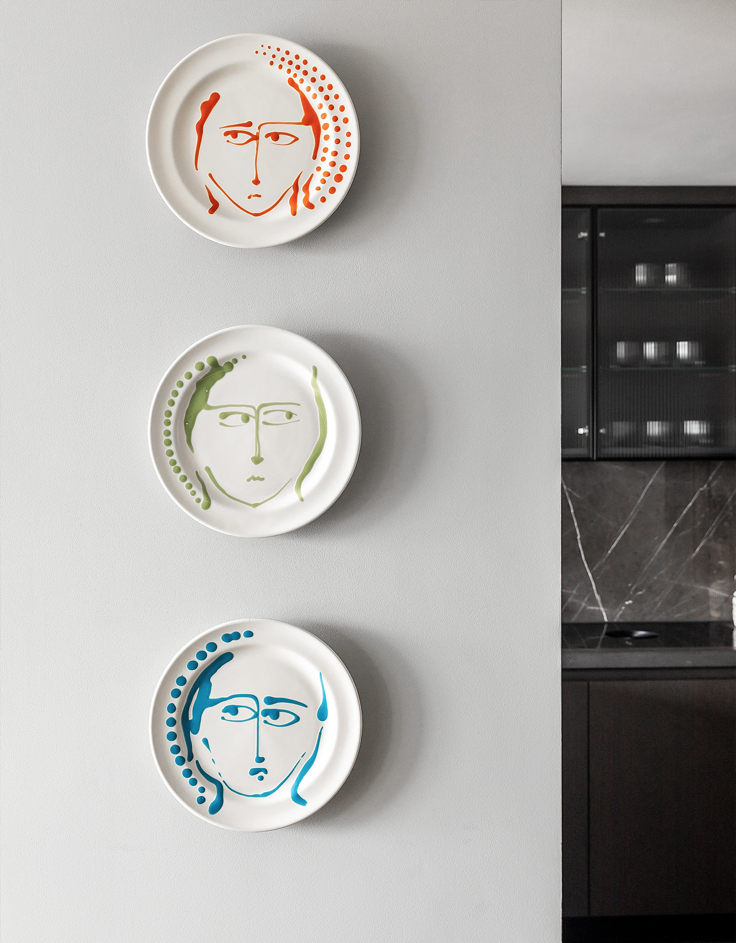 101 on Cleveland | hand painted faces on plates hung on the wall | Angel O'Donnell